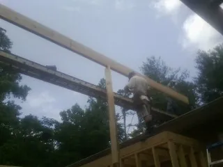 Carpenter setting a ridge beam over a new addition frame — Ice Dam Removal by Roofing Brothers in Robinson