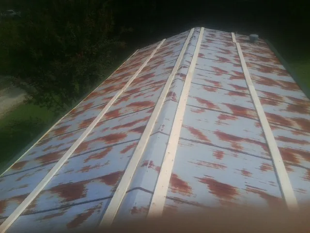 Rusted metal roof panels with new wood purlins before replacement — Storm Damage Roof Repair in Robinson by Roofing Brothers