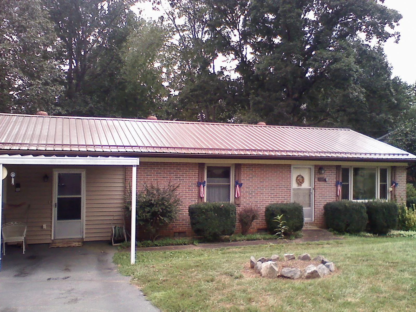 Bronze metal roof and carport on a brick ranch home — Roof Repair work by our crew in Robinson